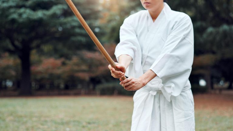 Training with a wooden staff - The Karate Shop Martial artist training outdoors with a wooden staff.