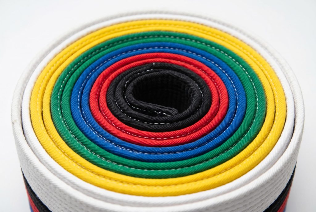 Karate belt colours coiled together - The Karate Shop Karate belts coiled one inside the other, showing grading colours from white through to black.